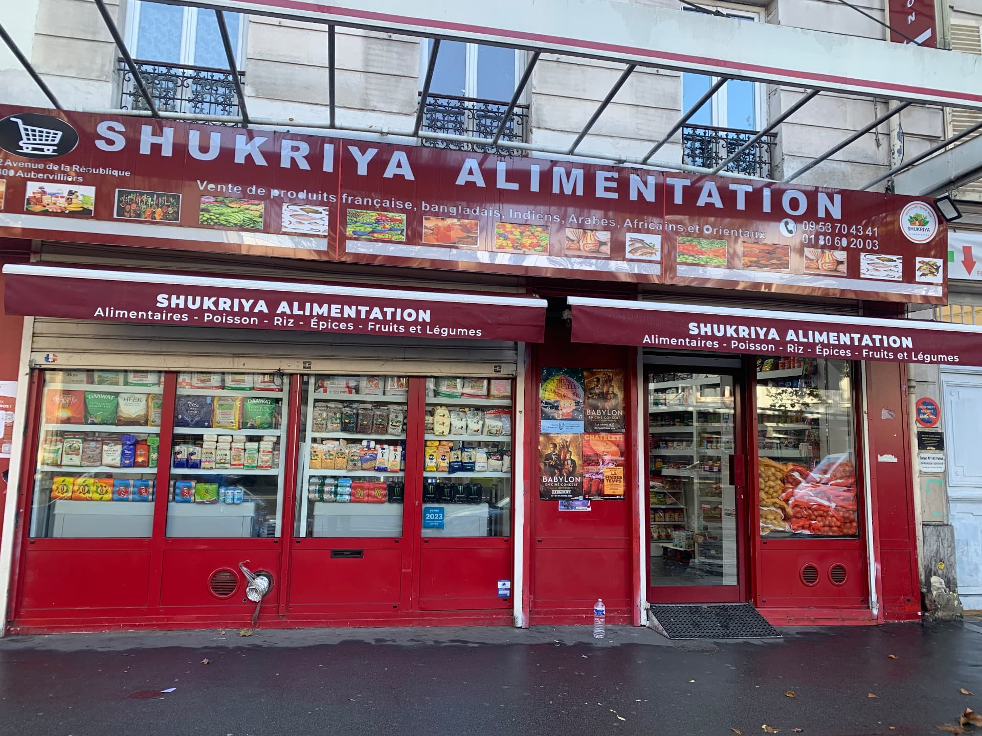 Vitrine de l'épicerie Shukriya Alimentation à Aubervilliers, sacs de pommes de terre et d'oignons en rayon